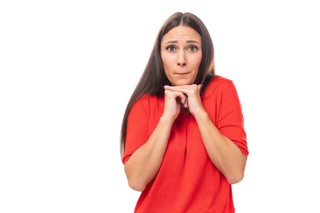 Surprised brunette woman in red stylish vneck blouse with eyes wide open