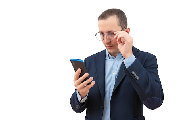 Surprised business man looks at a mobile phone on a white background business concept