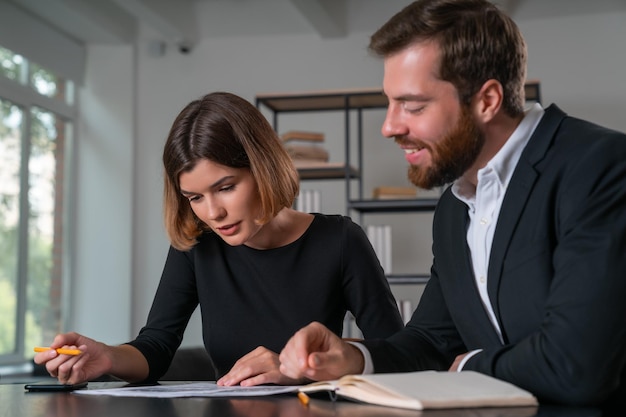 Surprised businessman and businesswoman in formal suit discuss contract