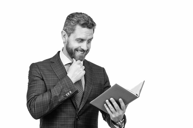 Удивленный бизнесмен в деловом костюме читает бизнес-отчет в блокноте, изолированном на белом графике