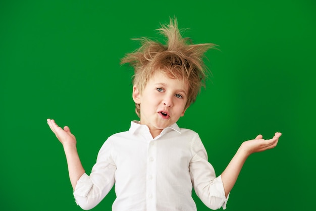 Surprised child against green chalkboard in class