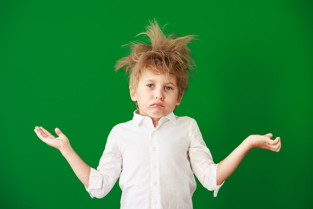 Surprised child against green chalkboard in class