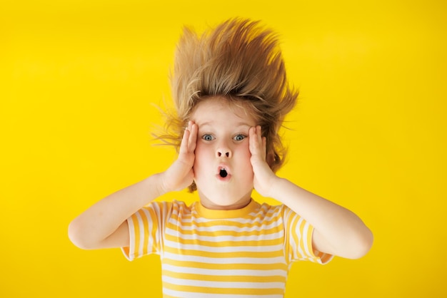 Surprised child against yellow background