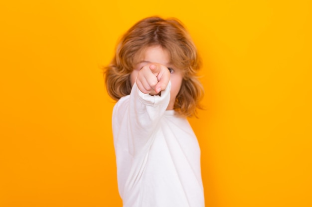 Surprised child pointing at you on yellow isolated studio background shocked kid pointing to copyspa