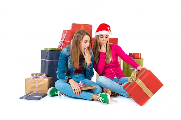 Surprised christmas women holding gifts over white background