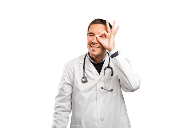 Surprised doctor with search gesture against white background