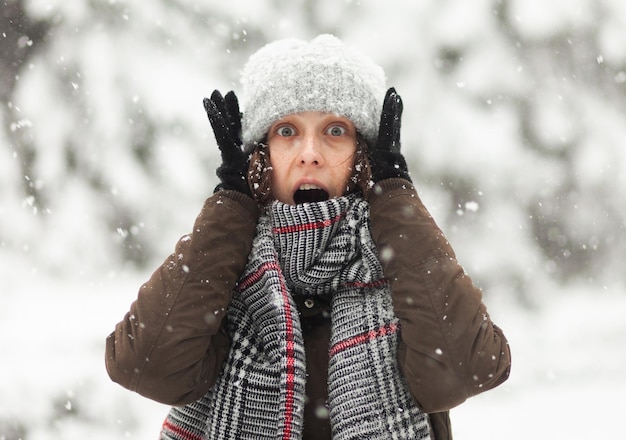 Donna emotiva sorpresa in abiti caldi in inverno nevoso