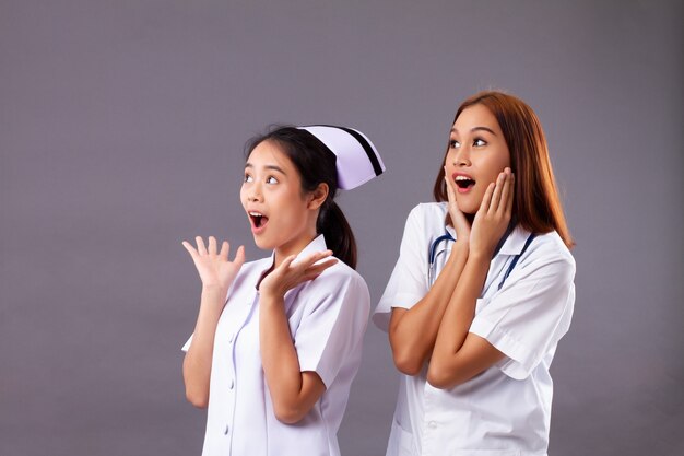 Surprised excited professional female doctor and nurse, medical team, health care worker looking up