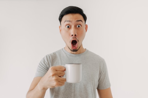 Surprised face of man drinks a cup of coffee isolated on white background