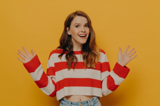 Photo surprised female losing speech from amazement while standing isolated over yellow background