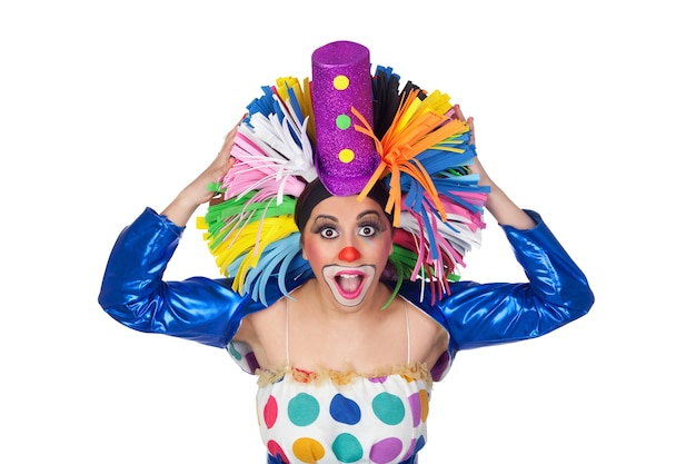 Surprised girl clown with a big colorful wig isolated on white background