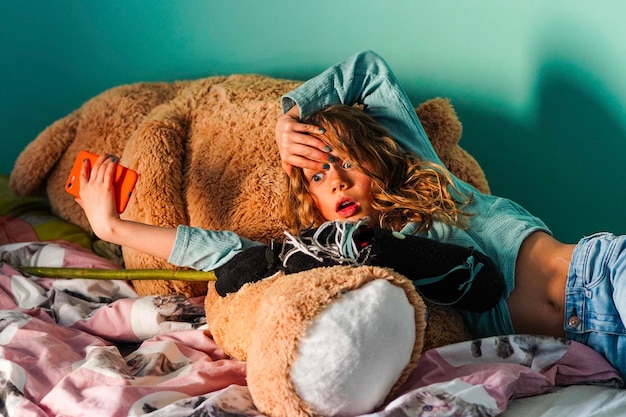 surprised girl lying on teddy bear