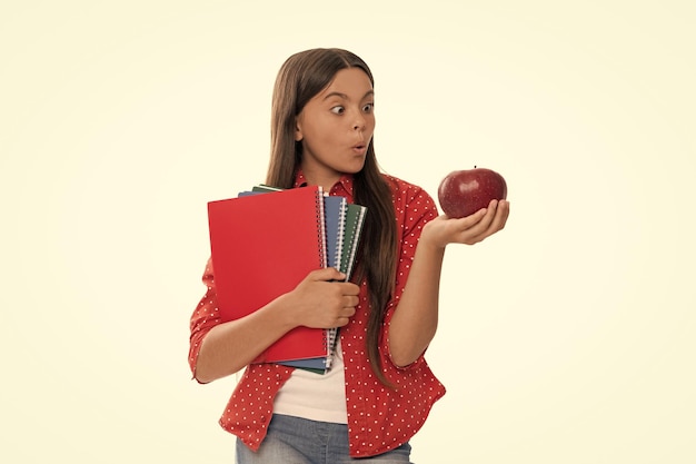 Surprised girl with notebook back to school child with apple\
ready to study healthy childhood