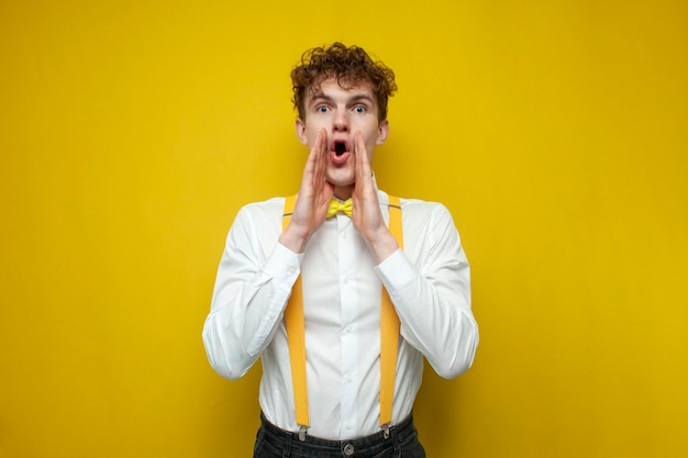 Surprised guy in white bowtie shirt and suspenders shouts and announces information