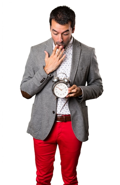 Photo surprised handsome man holding vintage clock