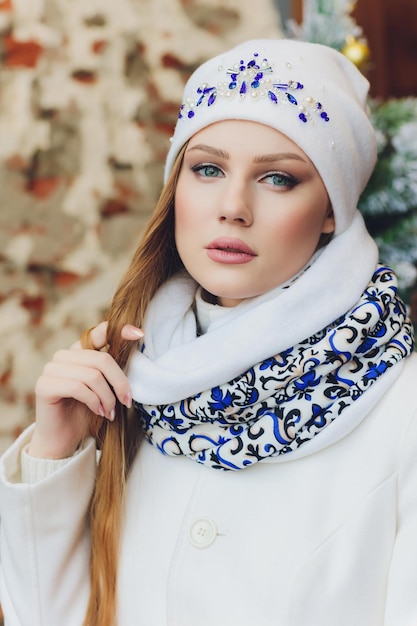 Surprised happy beautiful woman looking sideways in excitement Christmas girl wearing knitted warm hat and mittens isolated on gray background