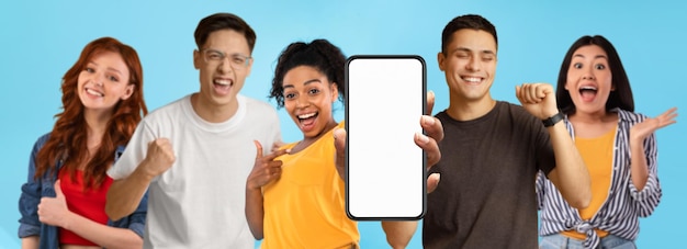 Surprised happy millennial asian black and caucasian people point finger at smartphone with blank screen