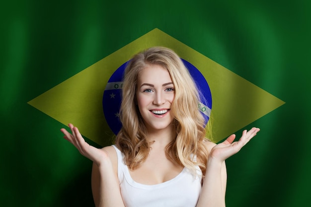 ブラジル国旗を背景にした驚いた幸せな女性