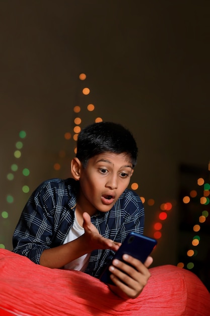 Surprised indian little child after seeing in smart phone