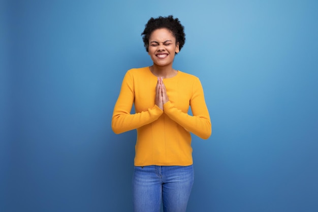 Surprised joyful young brunette latin female adult in yellow sweater is happy