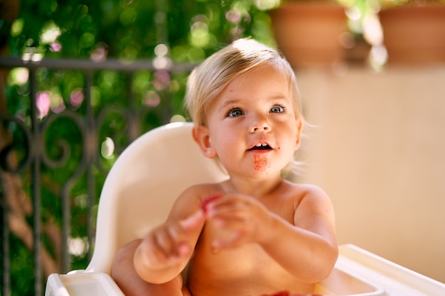 Surprised kid holds raspberry on his finger