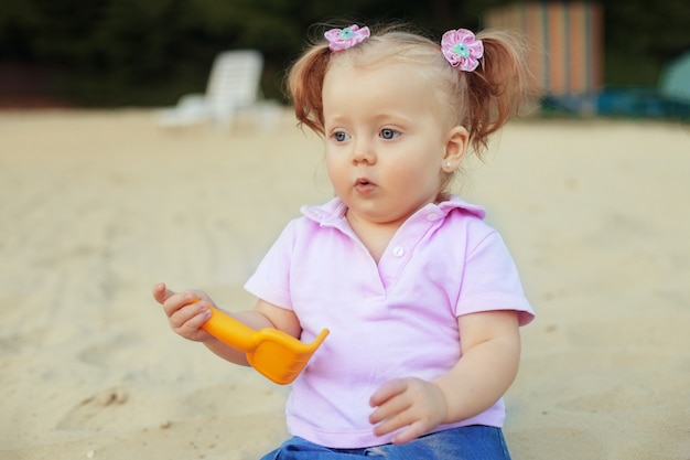 Surprised little girl playing in the sand. 