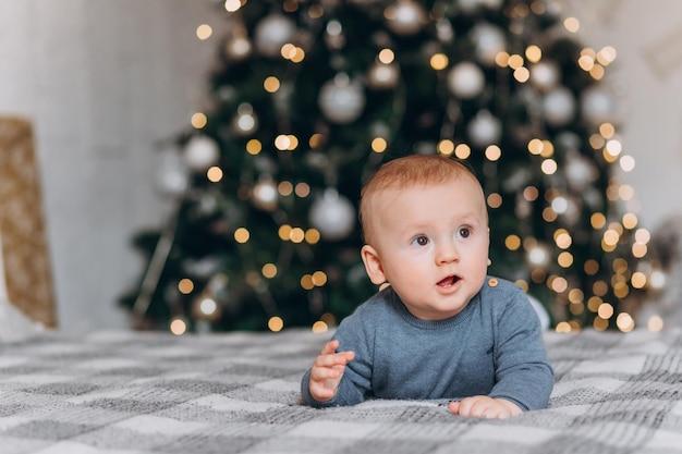 Surprised look. Lovely family sits near the Christmas tree with gift boxes on winter evening