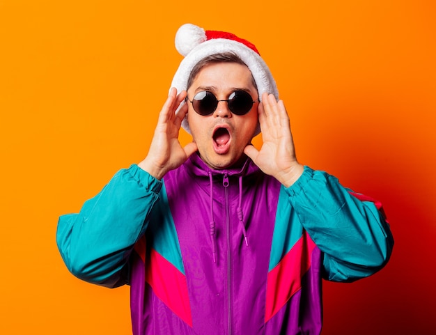 Surprised man in 80s tracksuit and Christmas hat