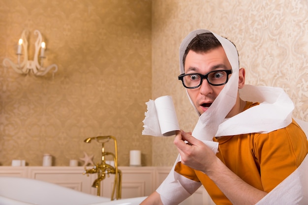 Surprised man in glasses sitting on toilet bowl