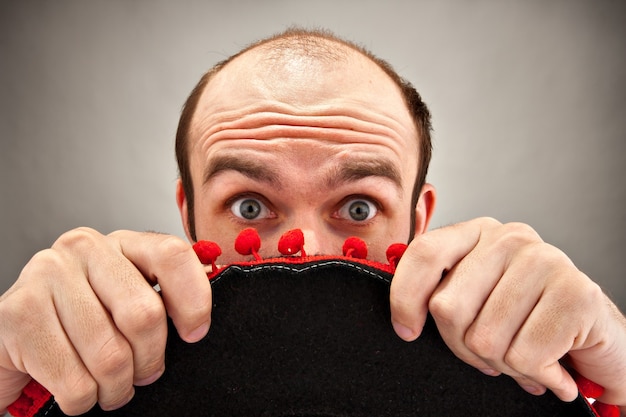 Photo surprised man hiding behind sombrero hat