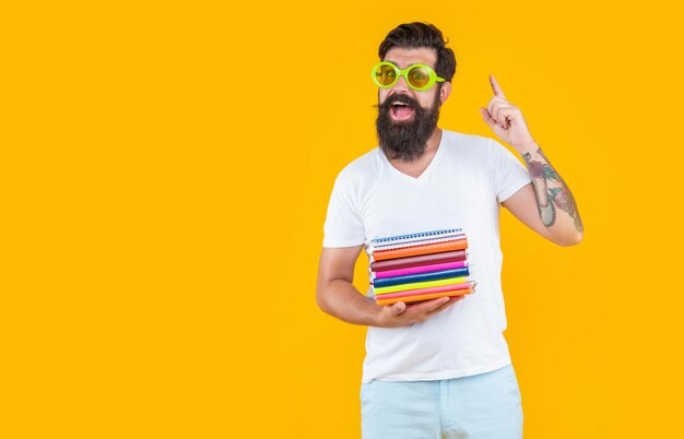 Surprised man student with book stack for school man in glasses hold school book stack