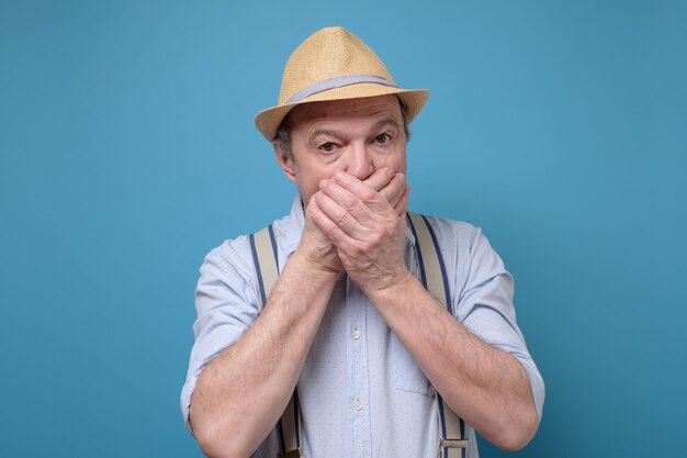 Surprised man with hands covering mouth eyes wide open in full disbelie