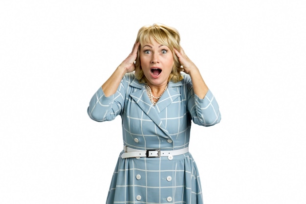 Surprised mature woman open mouth. Astonished white-skin lady hold hands on head with open mouth on white