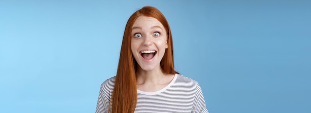 Surprised pleased happy impressed redhead european girl s reacting amused wide eyes look admiration