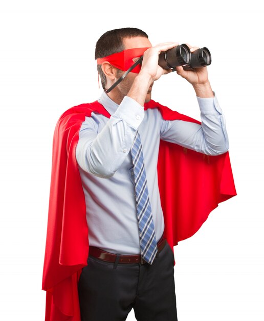 Surprised super businessman using a binoculars