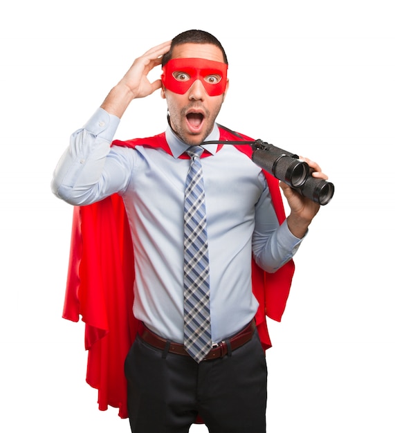 Photo surprised super businessman using a binoculars