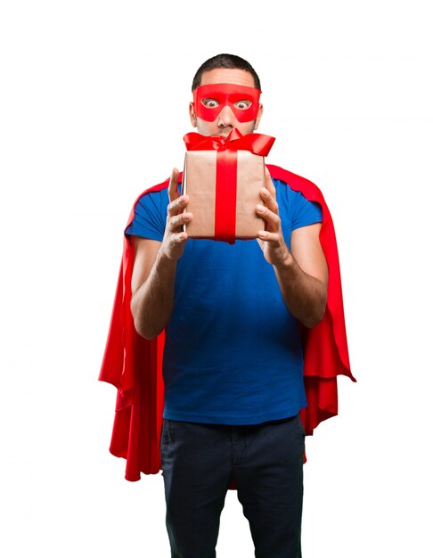 Foto superhero sorpreso con un regalo