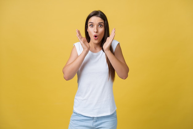 Surprised teenage girl show shocking expression with something. Isolated on Bright Yellow Background. Copy space