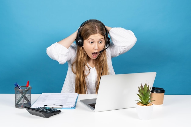 Surprised telemarketing operator in front of laptop