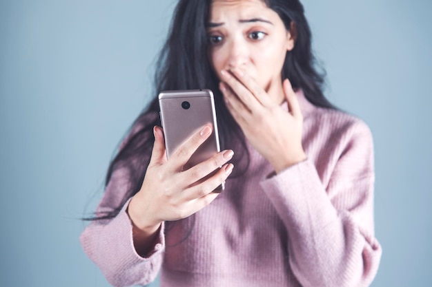 Surprised woman hand holding phone