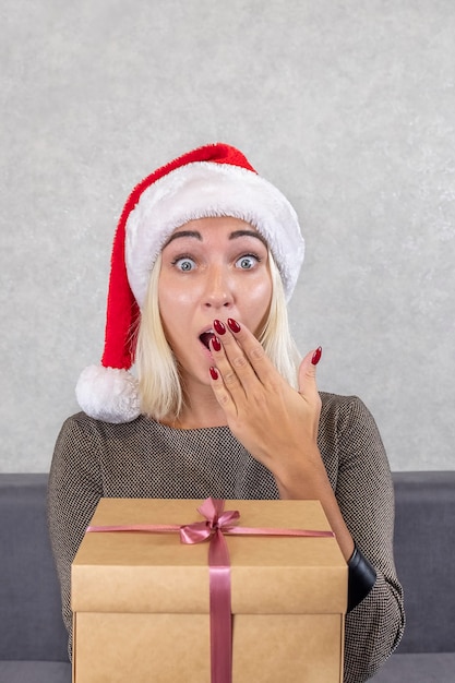 Foto donna sorpresa con il cappello di babbo natale