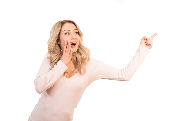 The surprised woman showing forefinger on the white background