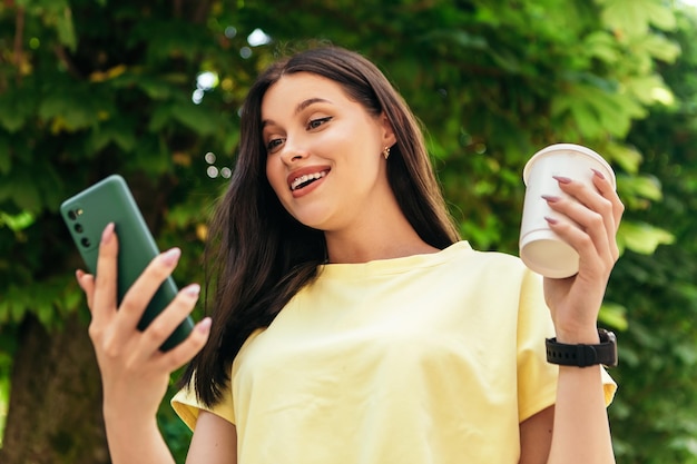 Surprised woman standing with phone outside