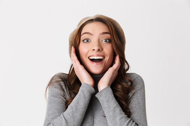 Foto donna sorpresa che indossa cappello sorridente e gioiosa isolata su muro bianco