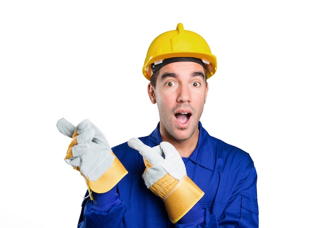 Surprised worker pointing on white background