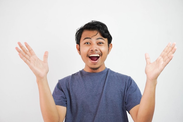 Surprised worry free handsome Asian man in casual clothes smiling and opening hands on isolated