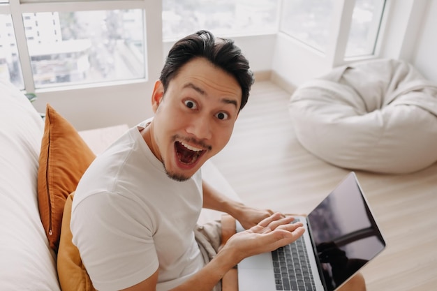 Surprised and wow face of man happy with the result in his tablet