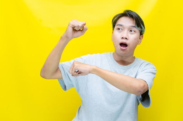 surprised young asian man pointing and advertising using hands and finger pointing