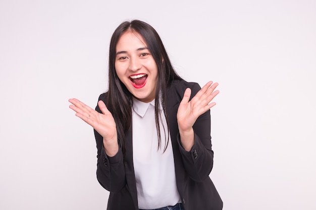 Surprised young asian woman on white wall