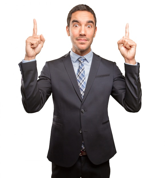 Surprised young businessman pointing up